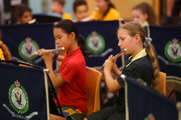 Two girls playing the flute as part of the school band.