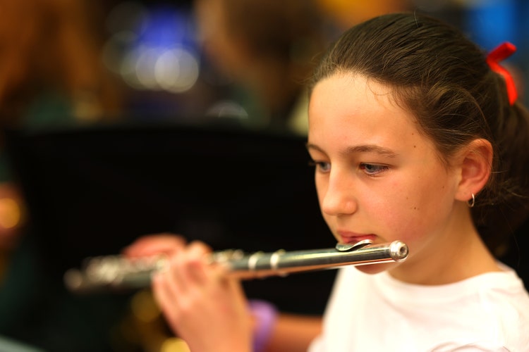 Girl student playing the flute.